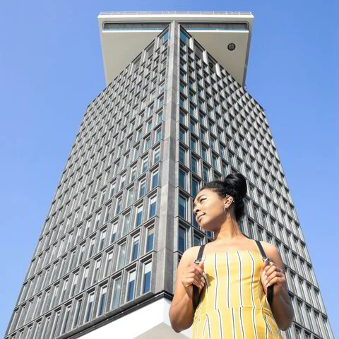 A woman standing confidently beside a tall building